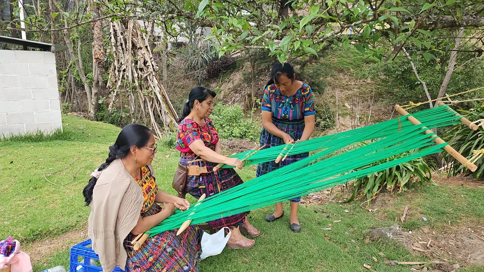 Mujeres preparando hilos para tejido en telar de cintura